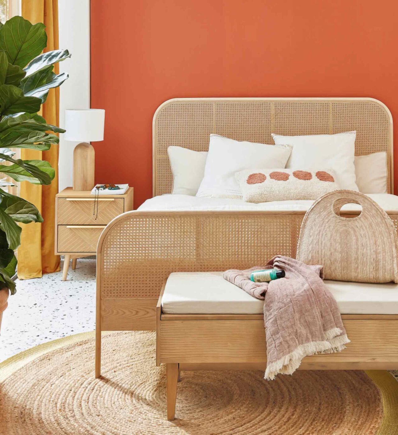 Une chambre à coucher avec un cadre de lit en bois et une boîte de rangement en bois au bout du lit.